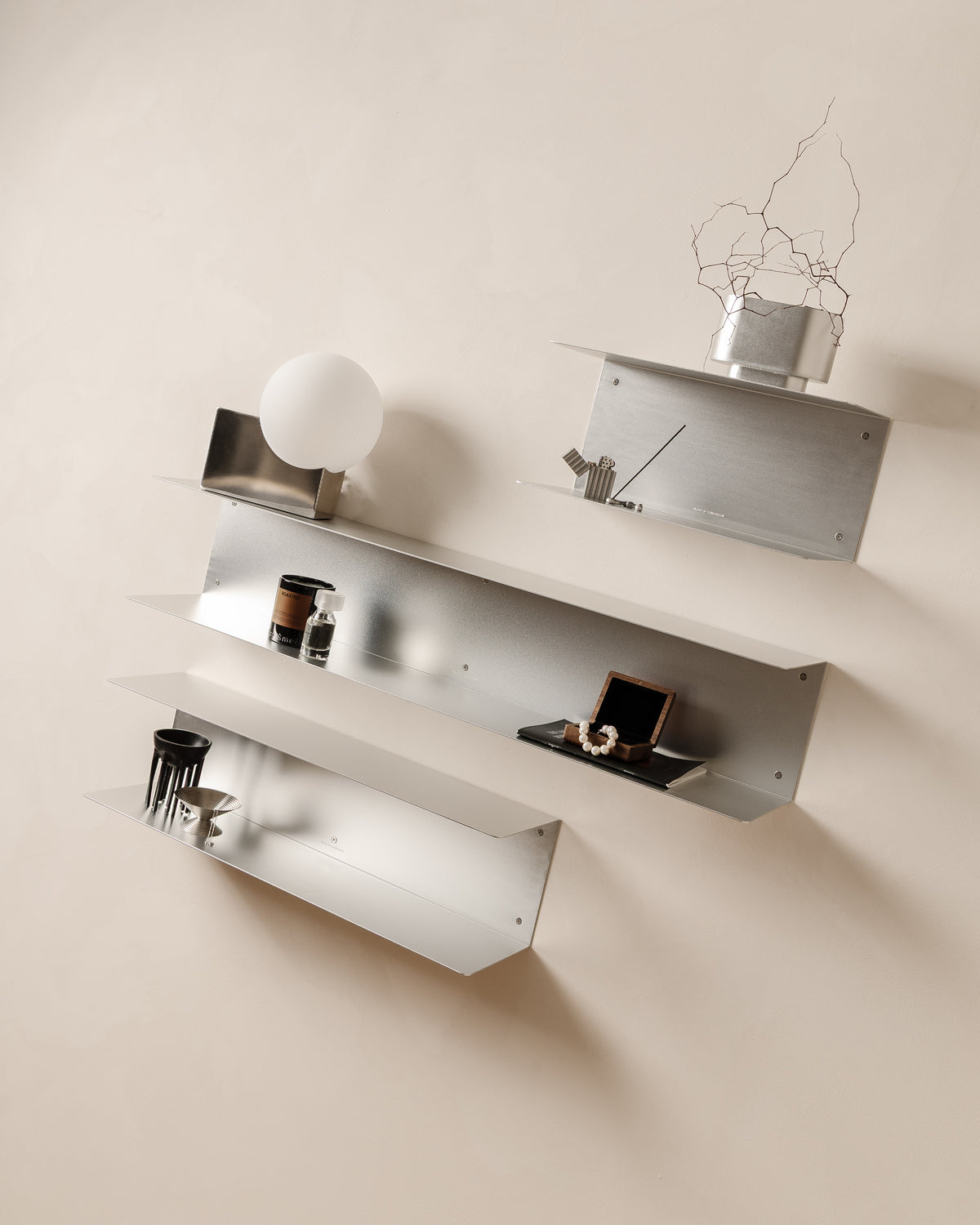 Three aluminium FOLD Double Shelves styled together on a wall