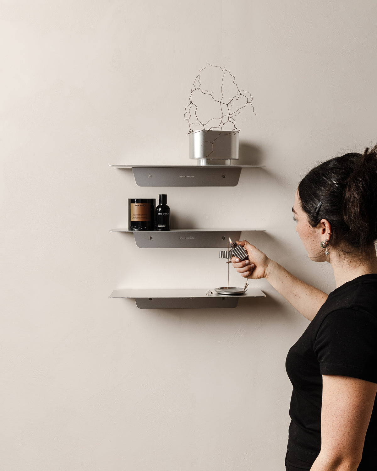 Three aluminium FOLD Ledge 450 shelves styled on a wall