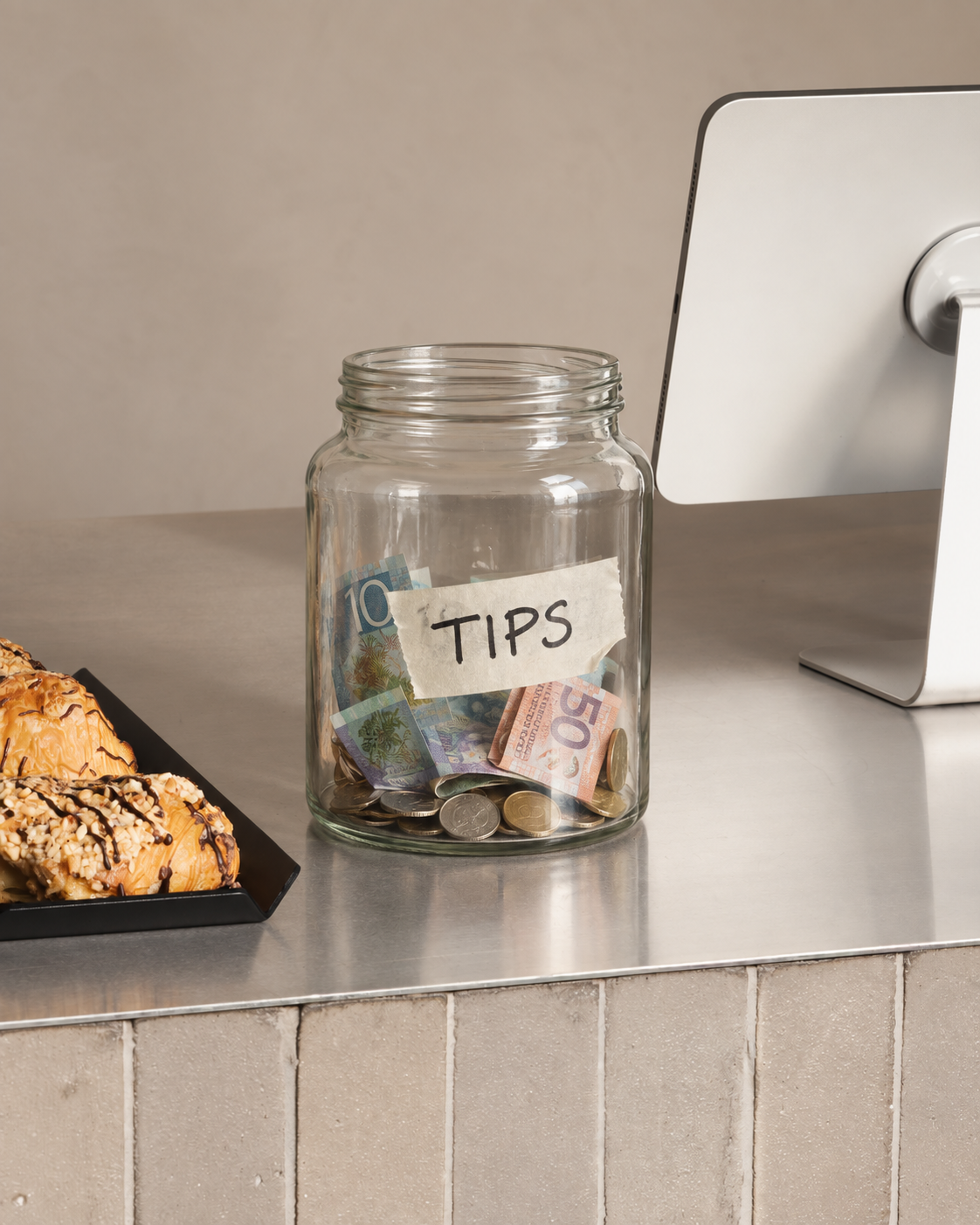 Plain glass tip jar on a café counter before switching to the FOLD Tip Box